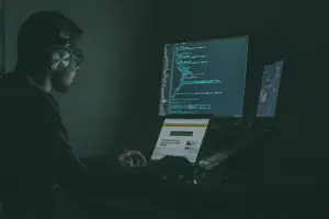 man sitting at computer in dark room