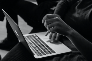 Black and white image of hands in laptop