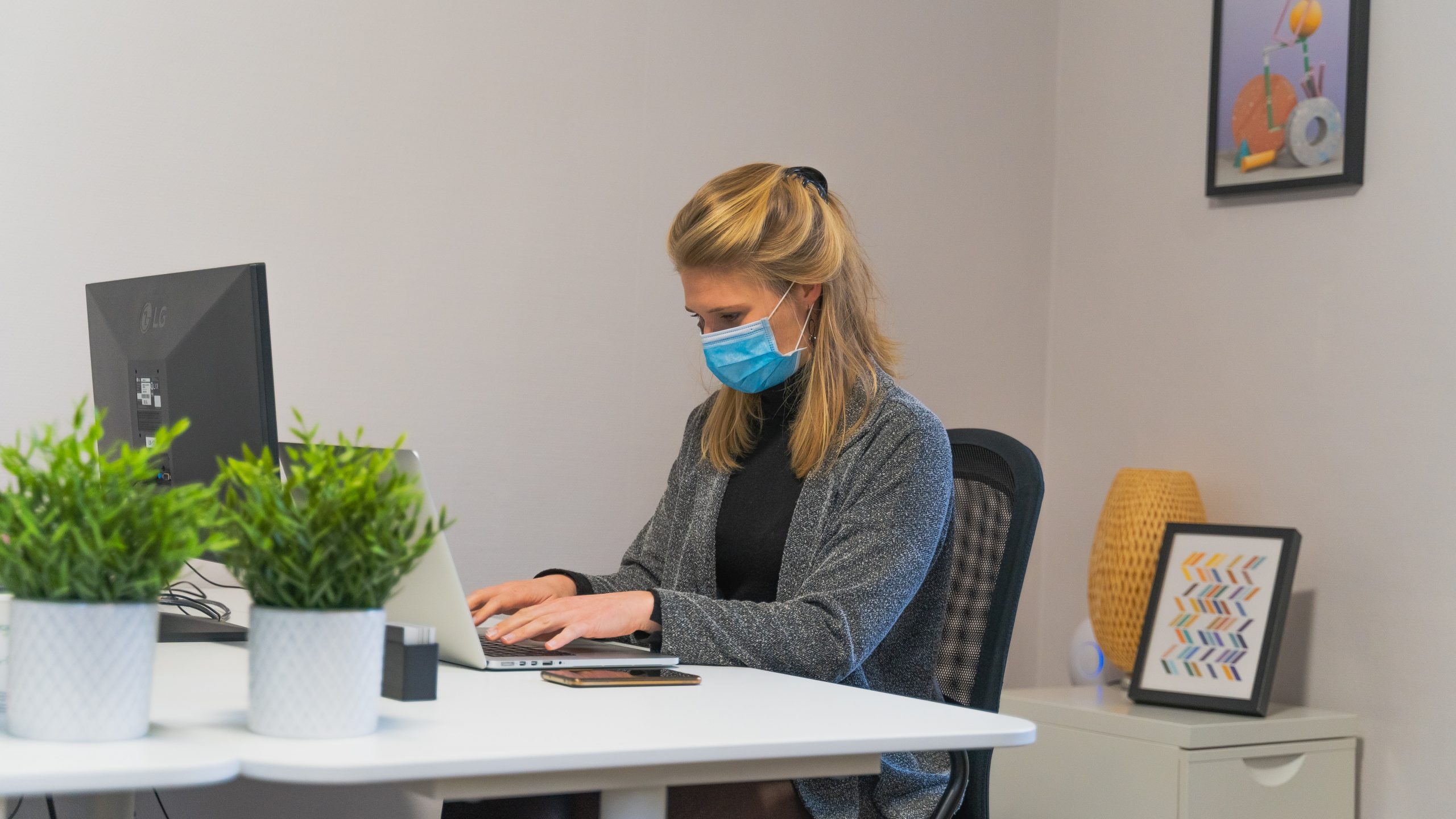 Woman with face mask working on her computer