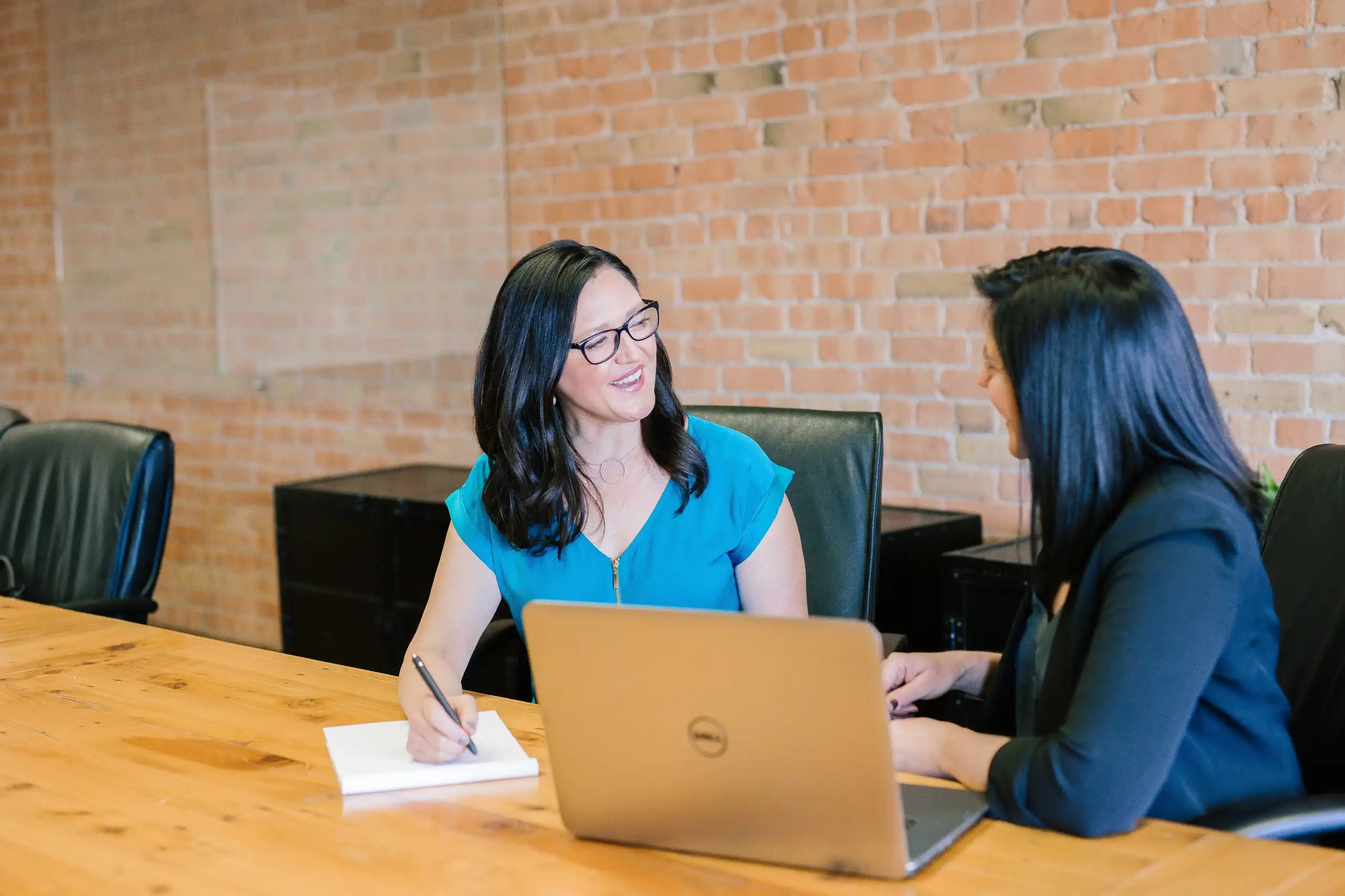 2 women talking in front of a computer
