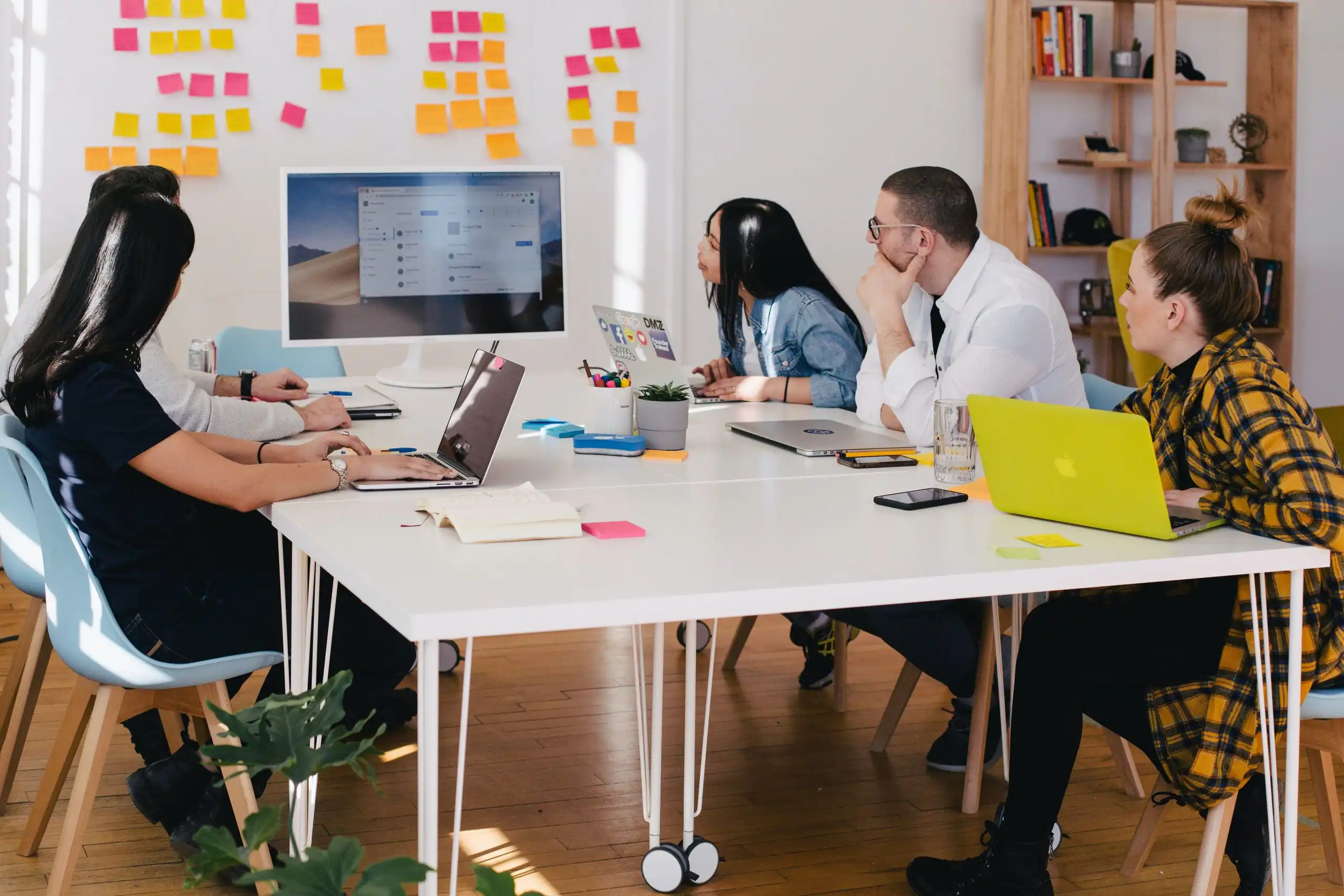 3 people working on an office with a whiteboard and computer